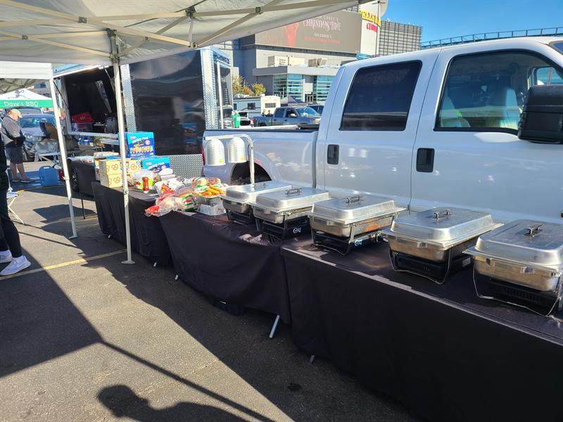 Row of chafing dishes on a buffet table beside the trailer