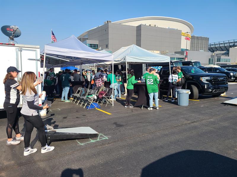 Guests playing cornhole beside the canopies outside an arena