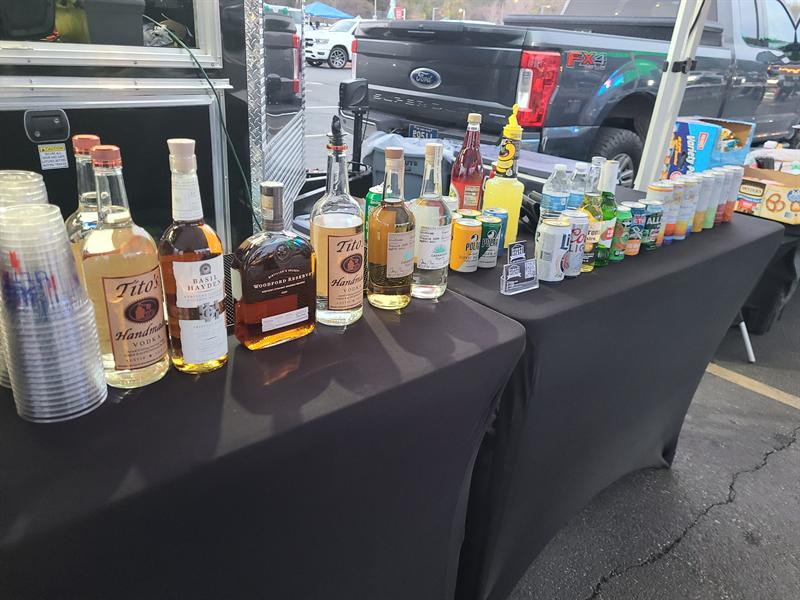 Drink table stocked with bottles, mixers and cups