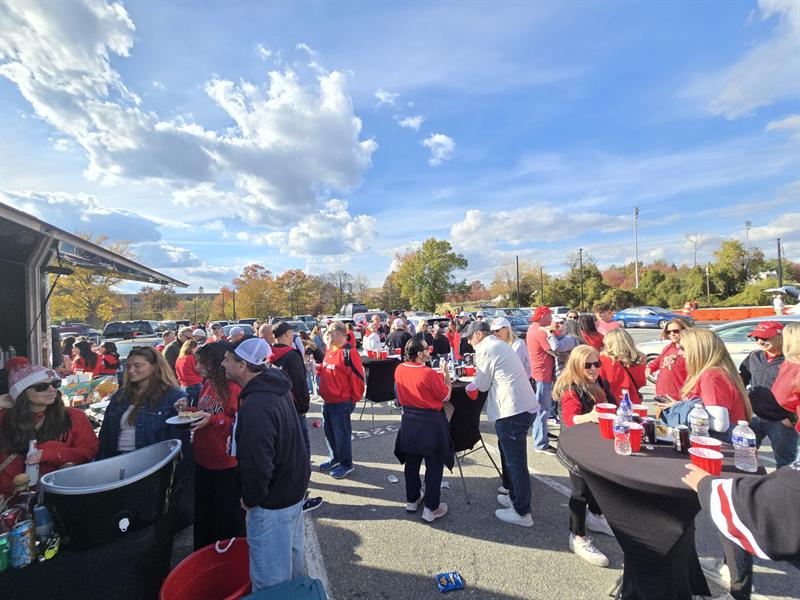 Fans in red gathered around cocktail tables under the canopies