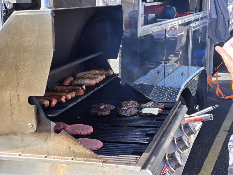 Burgers and hot dogs cooking on the trailer grill