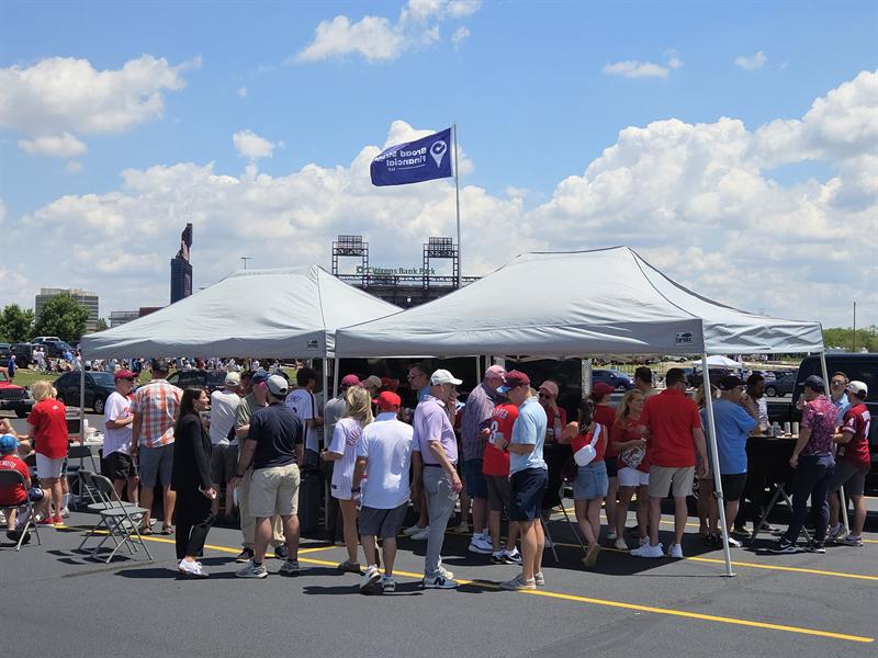 Guests gathered under canopies on a sunny summer day