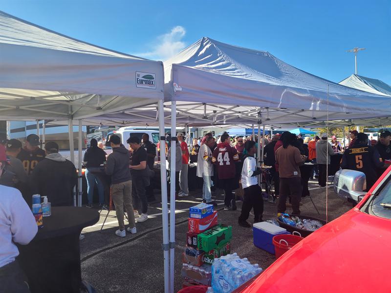 Guests in team jerseys mingling under the canopies